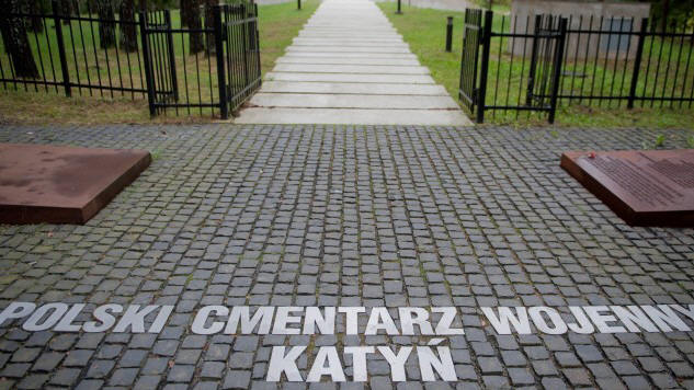 Blick auf einen Friedhof durch das Eingangstor, auf dem Boden stehen die Worte: Polski Cmentarz Wojenny Katyn (imago/stock&people/newspix)