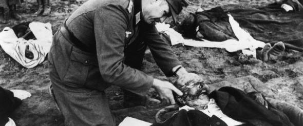 Ein Wehrmachtsoldat untersucht die Leiche eines getöteten Flüchlings bei Nemmersdorf Foto: picture allaince/akg-images